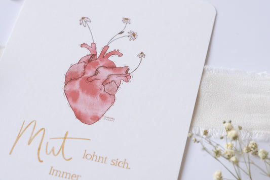 Postkarte mit Illustration eines anatomischen Herzens, aus dem Blumen wachsen, und dem Spruch „Mut lohnt sich. Immer.“ – inspirierende Grußkarte zur Ermutigung