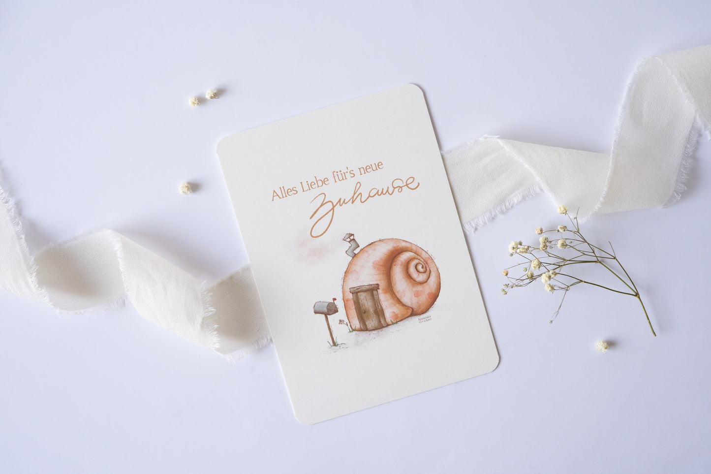 Postkarte mit Illustration eines Schneckenhauses und dem Text „Alles Liebe fürs neue Zuhause“ – Grußkarte zum Einzug oder Umzug