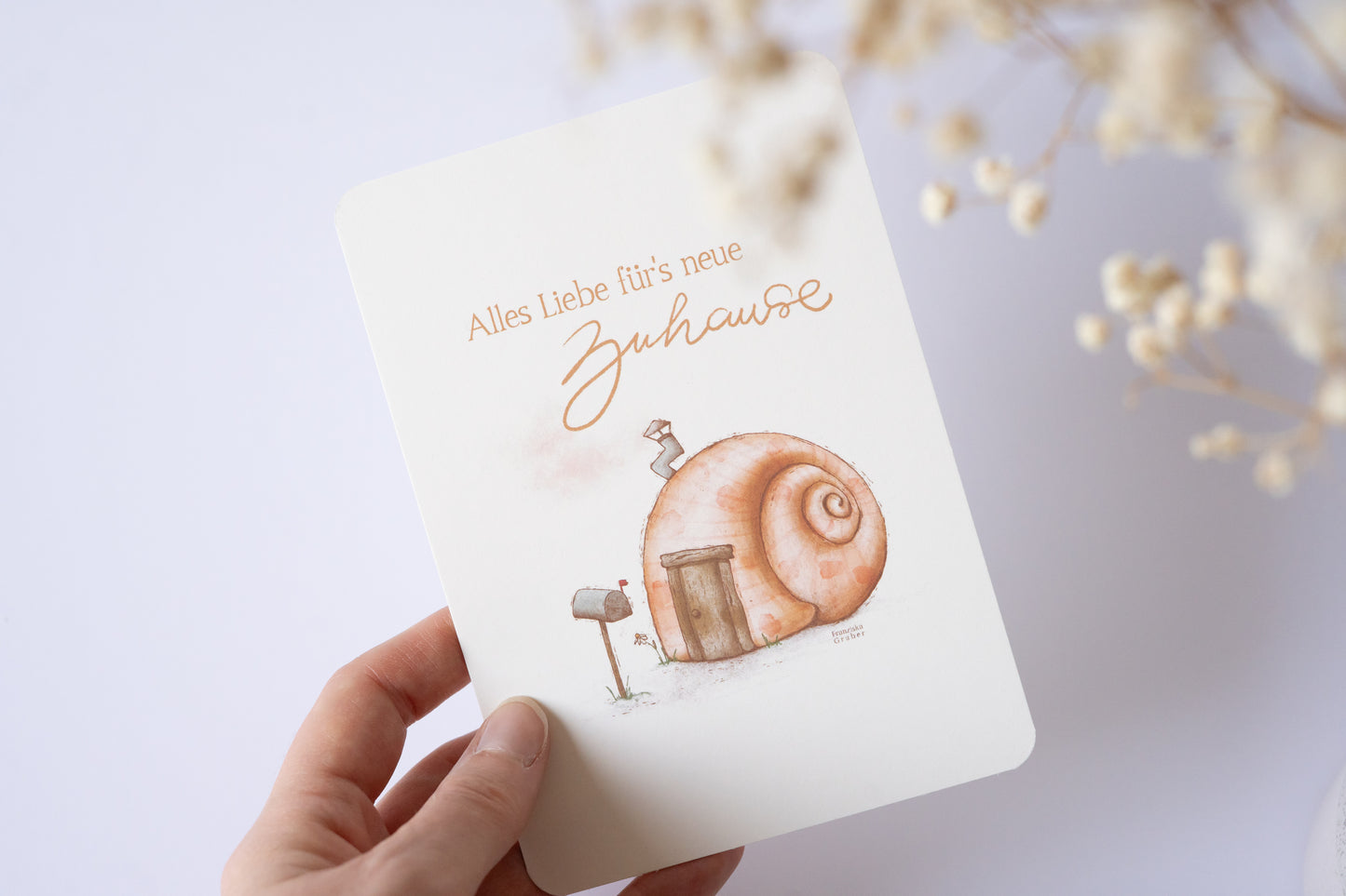 Postkarte mit Illustration eines Schneckenhauses und dem Text „Alles Liebe fürs neue Zuhause“ – Grußkarte zum Einzug oder Umzug