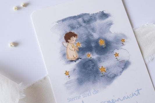Postkarte mit Engel und goldenen Sternen vor blauem Aquarellhintergrund und dem Spruch „Sterne sind die Vergissmeinnicht der Engel“ – Trauer- und Gedenkkarte.