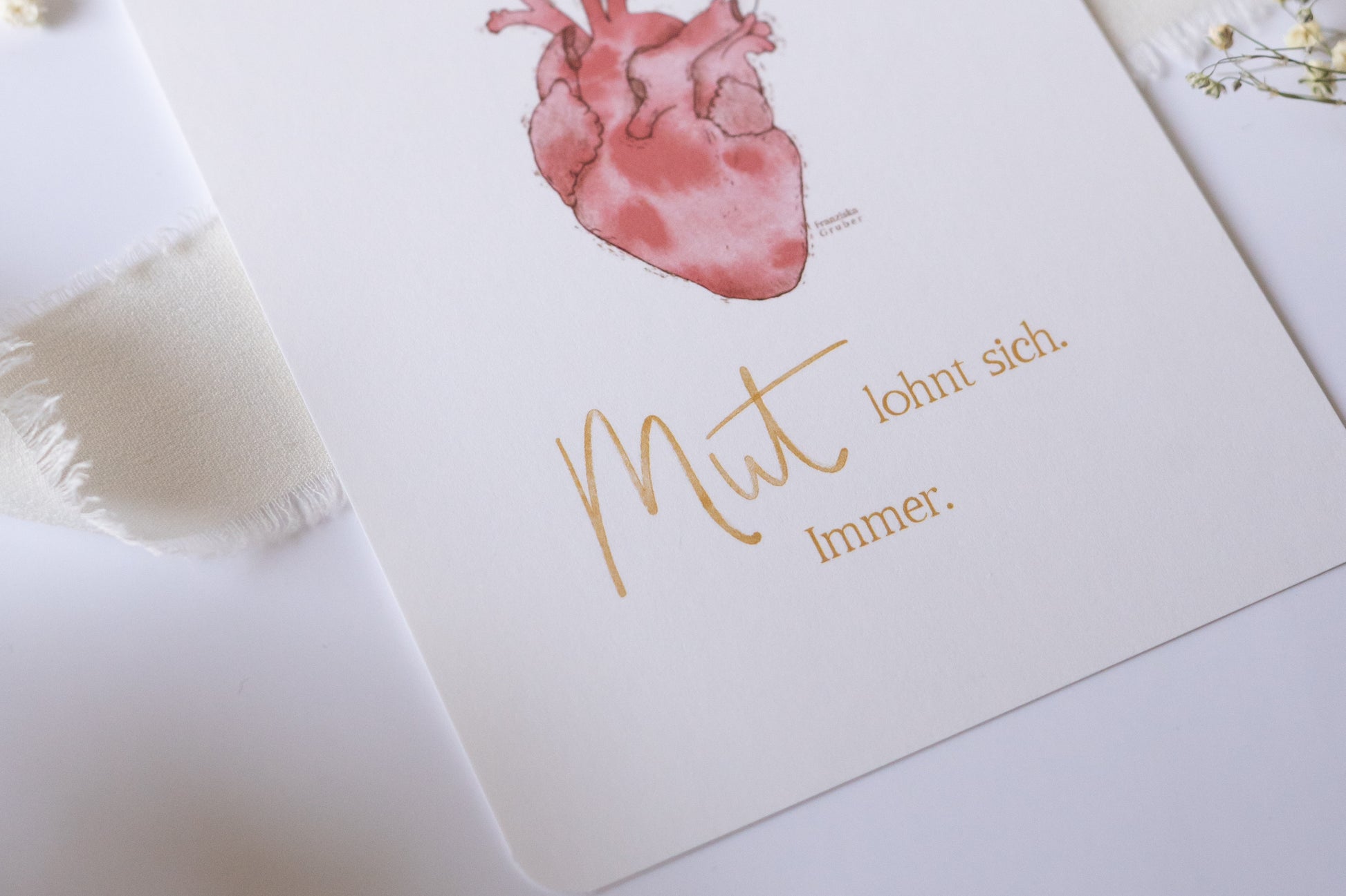 Postkarte mit Illustration eines anatomischen Herzens, aus dem Blumen wachsen, und dem Spruch „Mut lohnt sich. Immer.“ – inspirierende Grußkarte zur Ermutigung
