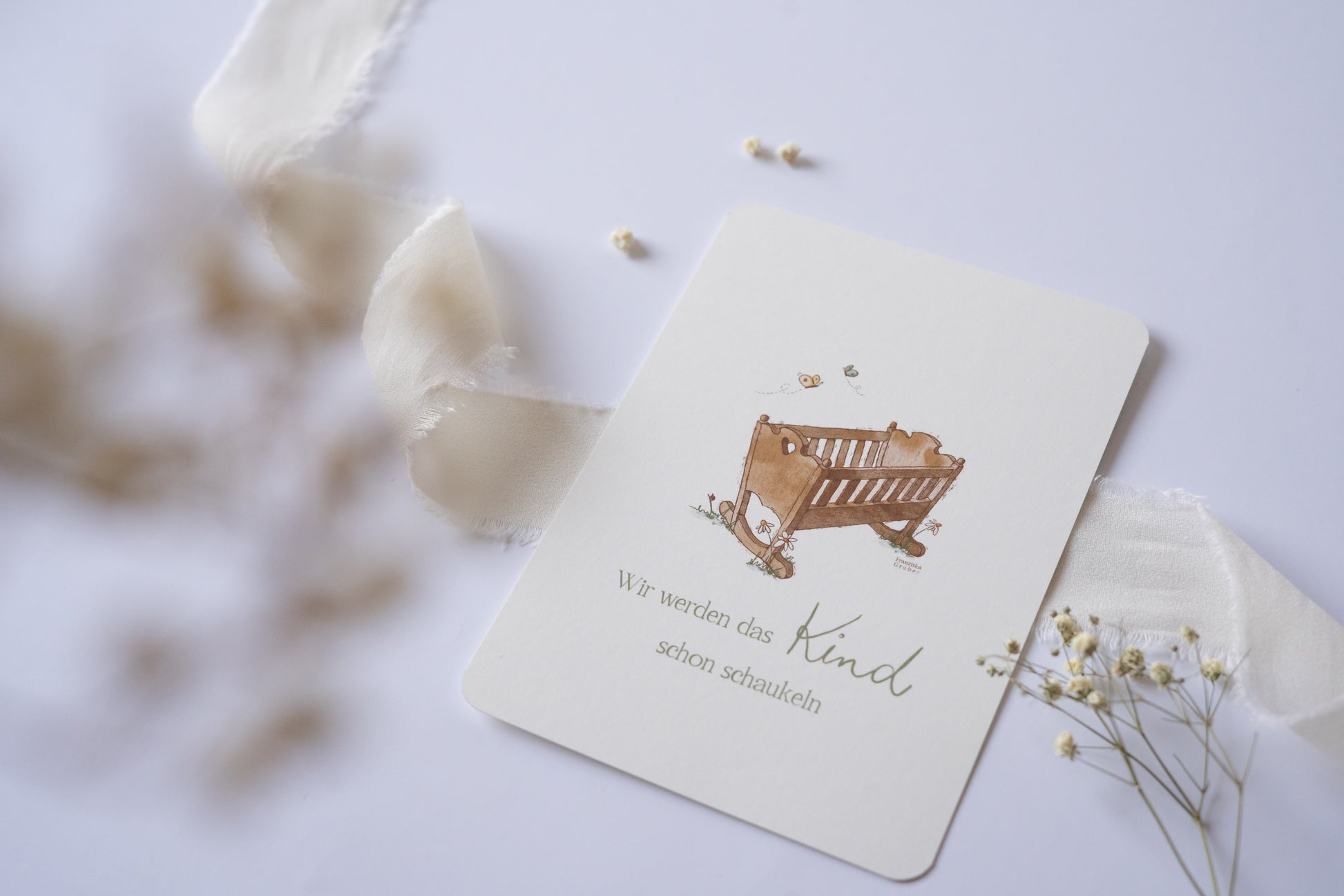 Postkarte mit handgezeichneter Babywiege und dem Spruch „Wir werden das Kind schon schaukeln“ – liebevolle Karte zur Geburt oder Taufe.