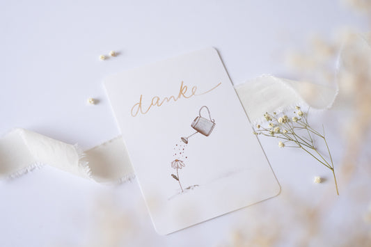 Postkarte Danke mit Illustration einer Blume und Gießkanne – zarte Dankeskarte