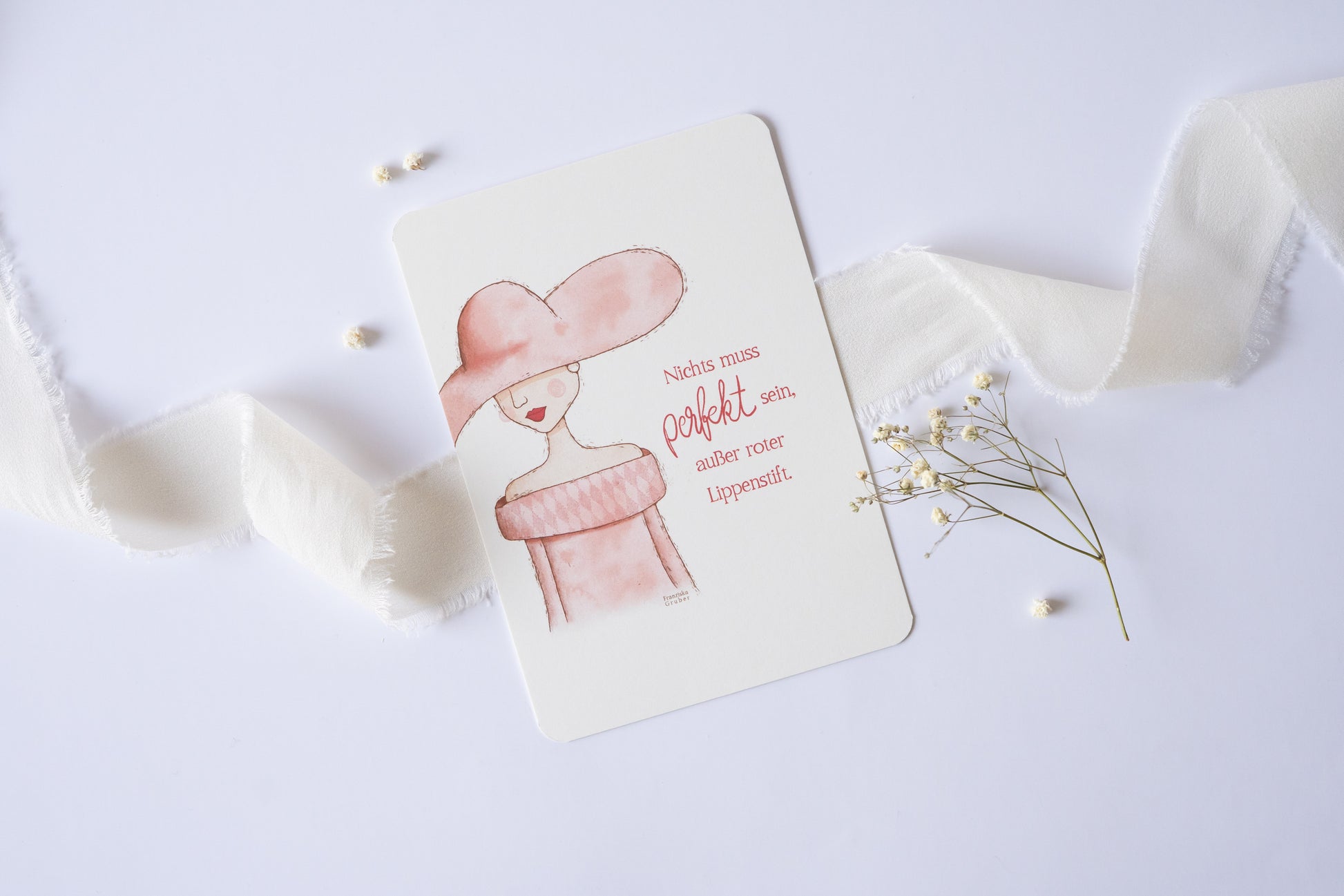 Postkarte mit Illustration einer Frau im Hut und rosa Kleid, Zitat „Nichts muss perfekt sein, außer roter Lippenstift“