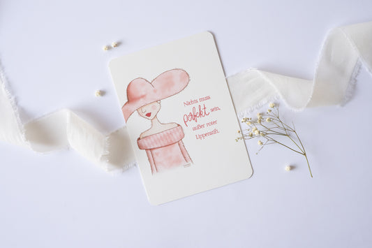 Postkarte mit Illustration einer Frau im Hut und rosa Kleid, Zitat „Nichts muss perfekt sein, außer roter Lippenstift“