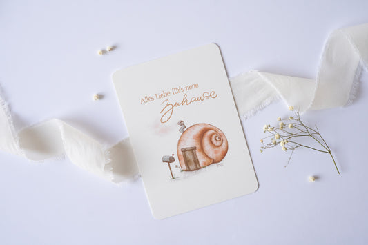 Postkarte mit Illustration eines Schneckenhauses und dem Text „Alles Liebe fürs neue Zuhause“ – Grußkarte zum Einzug oder Umzug
