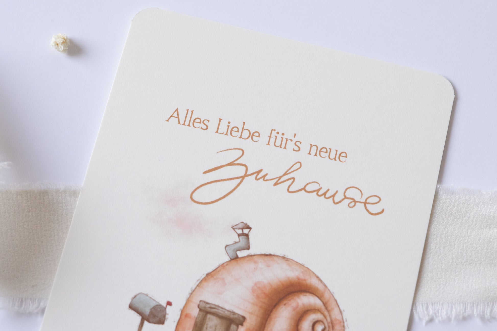 Postkarte mit Illustration eines Schneckenhauses und dem Text „Alles Liebe fürs neue Zuhause“ – Grußkarte zum Einzug oder Umzug