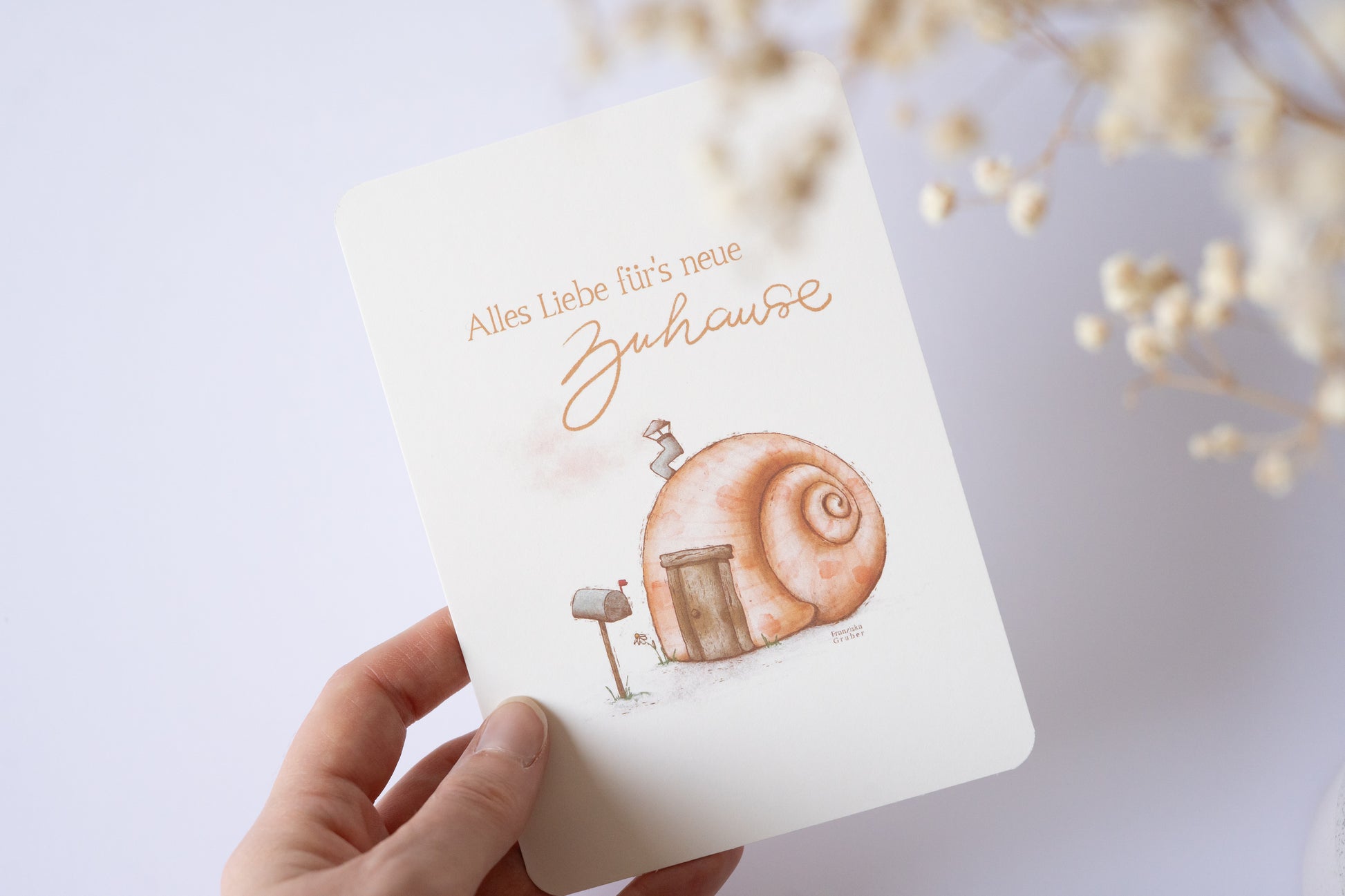 Postkarte mit Illustration eines Schneckenhauses und dem Text „Alles Liebe fürs neue Zuhause“ – Grußkarte zum Einzug oder Umzug