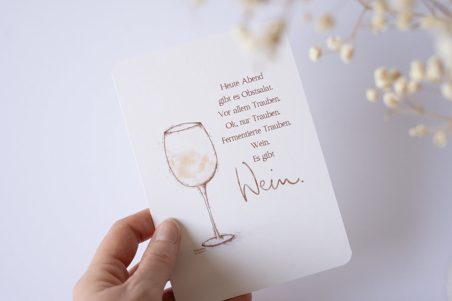 Postkarte mit zarter Illustration eines Weinglases und dem humorvollen Text „Heute Abend gibt es Obstsalat … Wein. Es gibt Wein.“ – lustige Karte für Weinliebhaber